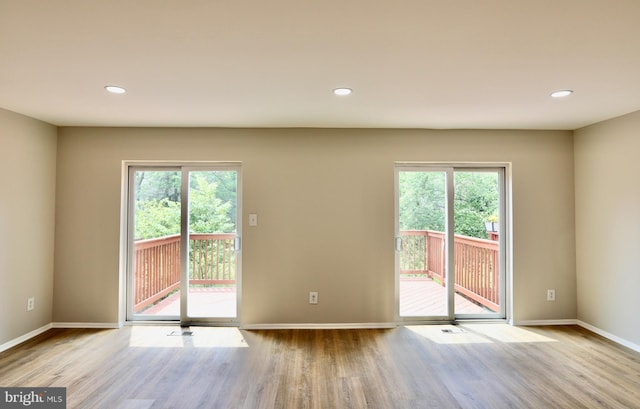 doorway to outside featuring baseboards, a healthy amount of sunlight, and wood finished floors
