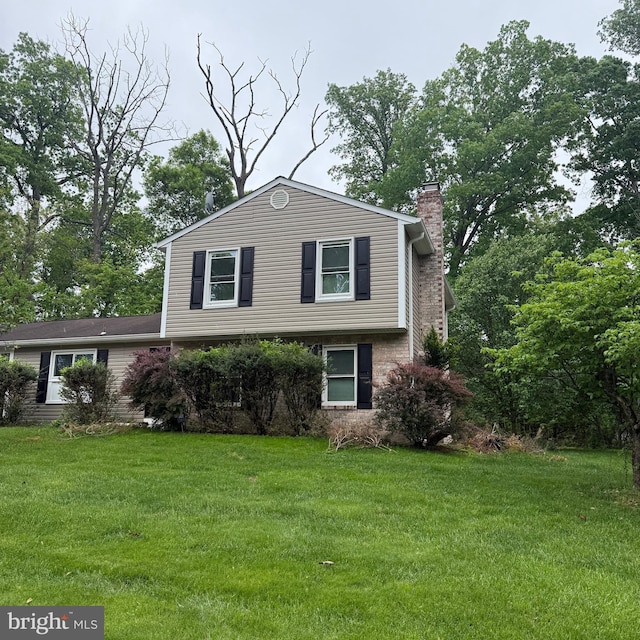 7813 Main Falls Cir, Baltimore, MD 21228 - split level home with a chimney, a front yard, and brick siding