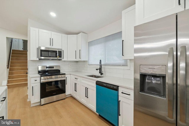 7813 Main Falls Cir, Baltimore, MD 21228 - kitchen featuring stainless steel appliances, a sink, light countertops, white cabinetry, and light wood-style floors