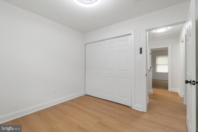7813 Main Falls Cir, Baltimore, MD 21228 - unfurnished bedroom with light wood-style flooring, baseboards, a closet, and attic access