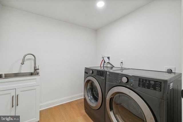 7813 Main Falls Cir, Baltimore, MD 21228 - clothes washing area with washer and dryer, cabinet space, light wood-type flooring, and baseboards