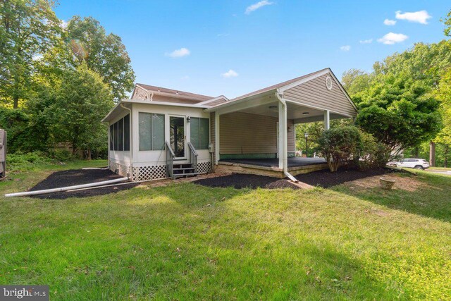 7813 Main Falls Cir, Baltimore, MD 21228 - rear view of house featuring a lawn, a sunroom, and an attached carport