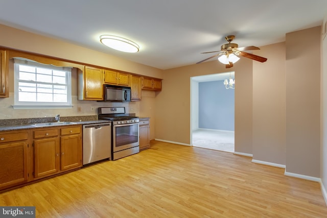 10703 Moray Ct, Cheltenham, MD 20623 - kitchen featuring appliances with stainless steel finishes, brown cabinets, a sink, dark countertops, and a ceiling fan