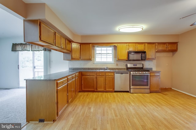 10703 Moray Ct, Cheltenham, MD 20623 - kitchen featuring appliances with stainless steel finishes, brown cabinetry, and light wood finished floors