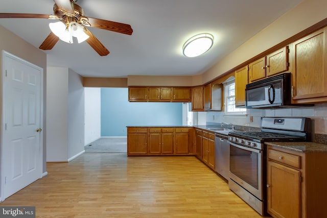 10703 Moray Ct, Cheltenham, MD 20623 - kitchen with stainless steel appliances, brown cabinets, a peninsula, and light wood-style floors