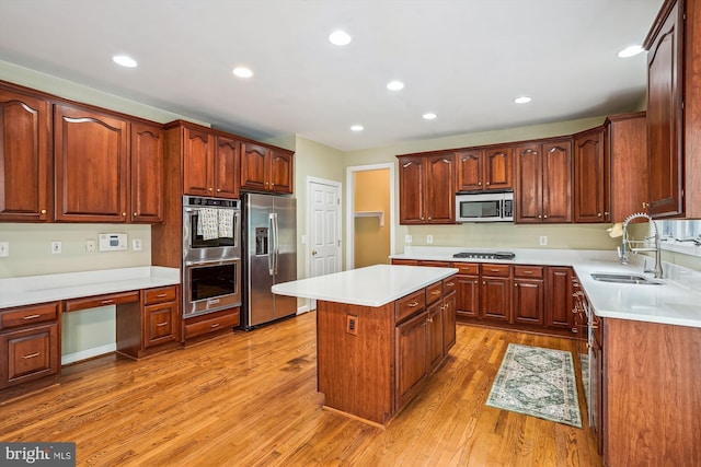 12630 Garry Glen Dr, Bristow, VA 20136 - kitchen with appliances with stainless steel finishes, a sink, a center island, light wood-style floors, and light countertops