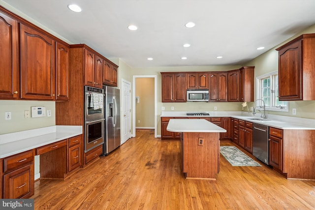 12630 Garry Glen Dr, Bristow, VA 20136 - kitchen featuring stainless steel appliances, a sink, a center island, light wood-style floors, and light countertops