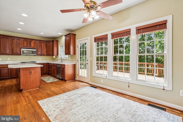12630 Garry Glen Dr, Bristow, VA 20136 - kitchen featuring stainless steel appliances, light countertops, wood finished floors, a center island, and baseboards