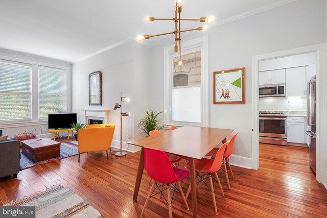 520 E Street Ne 105, Washington, DC 20002 - dining space featuring a notable chandelier, baseboards, ornamental molding, a fireplace, and light wood-type flooring