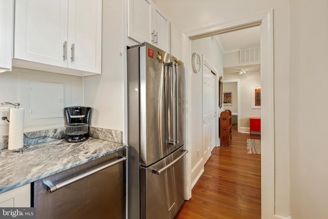 520 E Street Ne 105, Washington, DC 20002 - kitchen with wood finished floors, freestanding refrigerator, white cabinets, visible vents, and baseboards