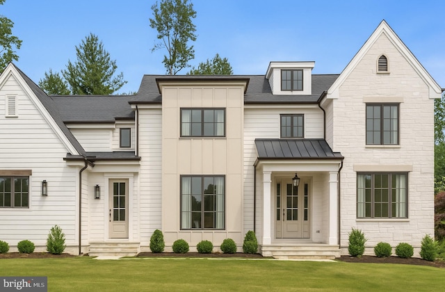 view of front of house with a front yard, a standing seam roof, roof with shingles, metal roof, and entry steps