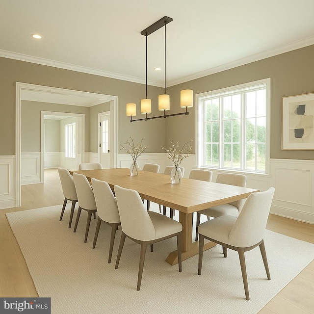 dining room with a wainscoted wall, a decorative wall, ornamental molding, light wood finished floors, and recessed lighting