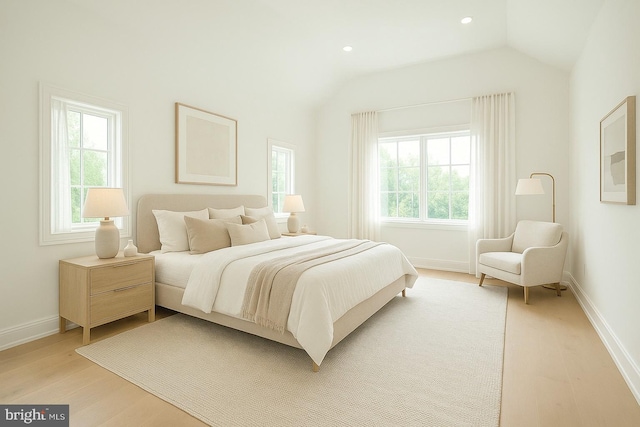 bedroom with light wood-style floors, lofted ceiling, baseboards, and recessed lighting