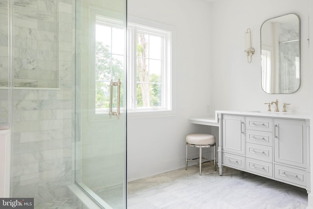 full bath featuring a tile shower, vanity, and baseboards