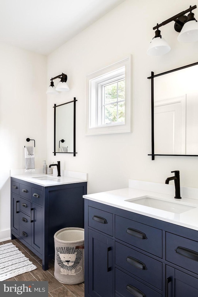 full bathroom with two vanities and wood finished floors