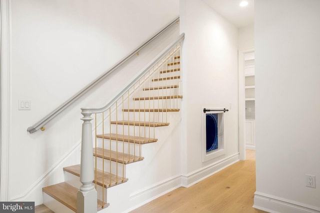 stairs featuring wood finished floors, recessed lighting, and baseboards