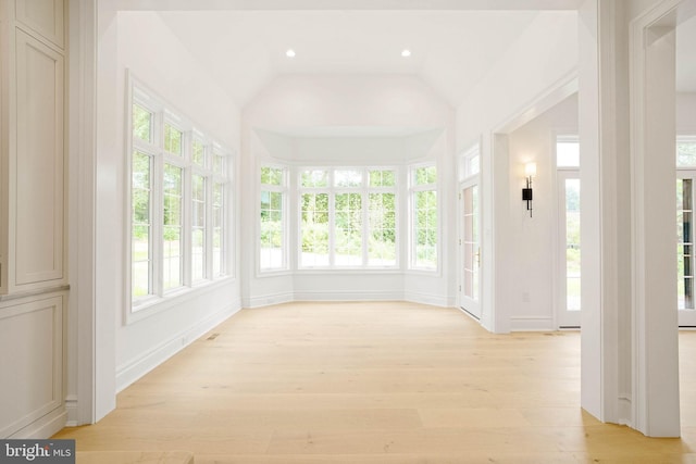 unfurnished sunroom featuring wood finished floors, recessed lighting, lofted ceiling, and baseboards