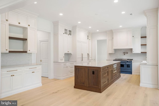 kitchen featuring range with two ovens, open shelves, stainless steel microwave, white cabinets, and recessed lighting
