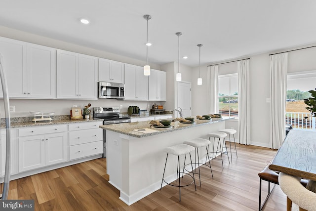 LOT484 Mountain Laurel Blvd Ashton, Unit Ashton, Ranson, WV 25438 - kitchen with light wood finished floors, white cabinets, a breakfast bar area, and appliances with stainless steel finishes