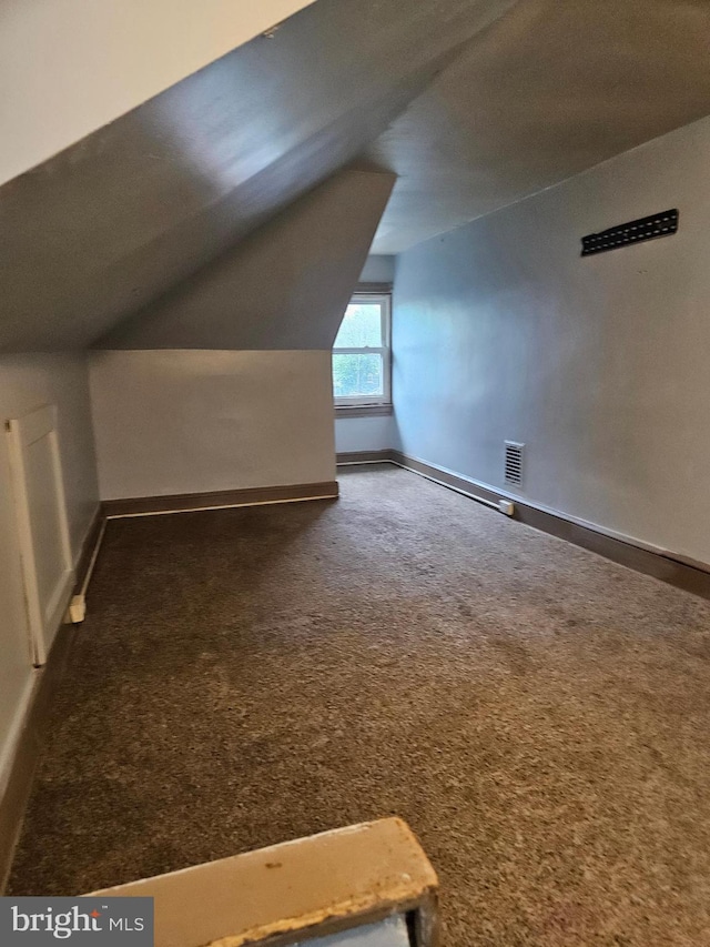 additional living space with carpet flooring, lofted ceiling, and baseboards