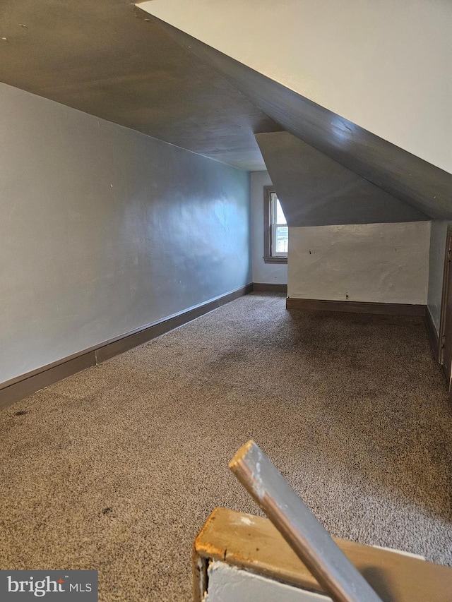 additional living space featuring baseboards, carpet flooring, and lofted ceiling