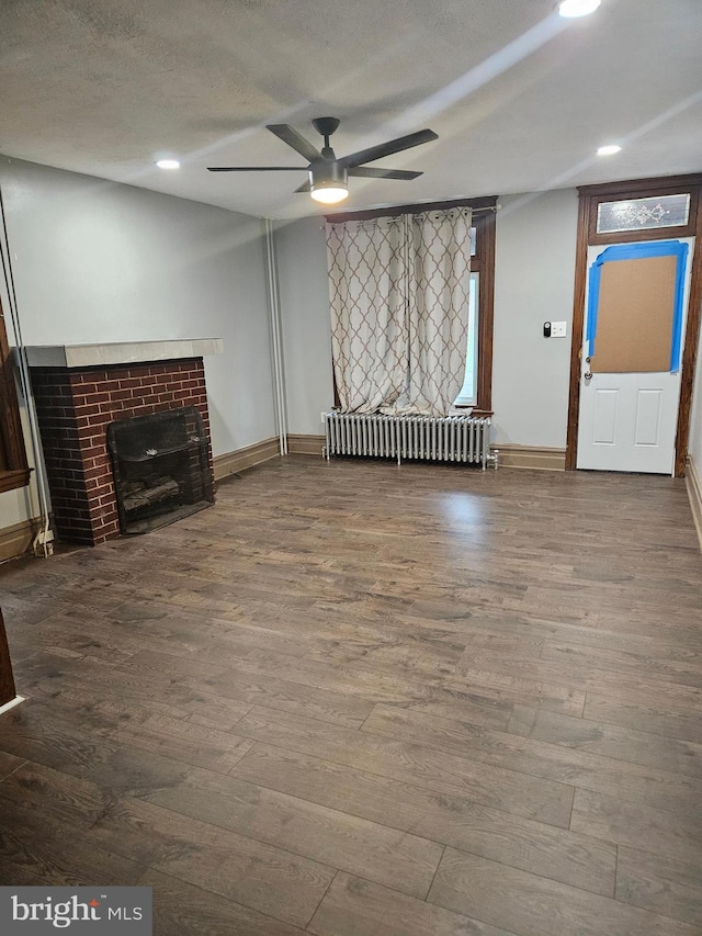 unfurnished living room featuring radiator heating unit, a ceiling fan, wood finished floors, recessed lighting, and baseboards