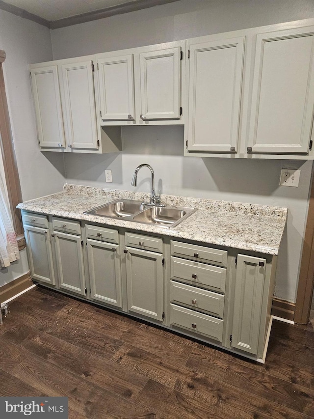 kitchen featuring a sink, dark wood-type flooring, and gray cabinets