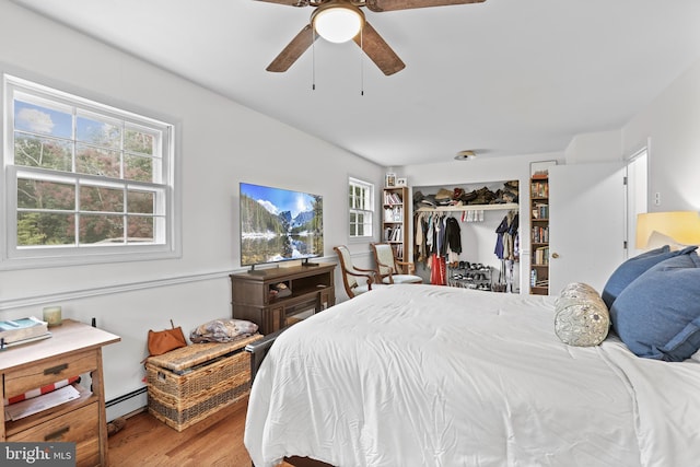 443 Deerwood Dr, Fredericksburg, VA 22401 - bedroom with baseboard heating, wood finished floors, a closet, and a ceiling fan