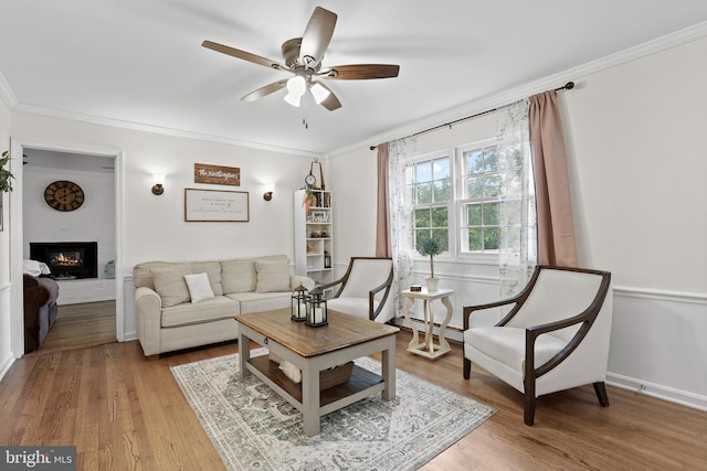 443 Deerwood Dr, Fredericksburg, VA 22401 - living room featuring a ceiling fan, crown molding, light wood-type flooring, a brick fireplace, and baseboard heating