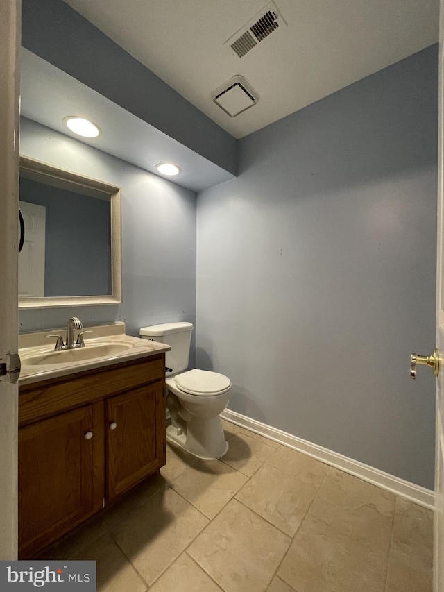 bathroom featuring toilet, vanity, baseboards, and recessed lighting