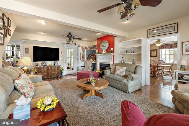 38967 Willow Ln, Fenwick Island, DE 19944 - living area featuring a ceiling fan, wood finished floors, and a glass covered fireplace