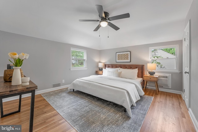 bedroom featuring light wood-type flooring, visible vents, and multiple windows