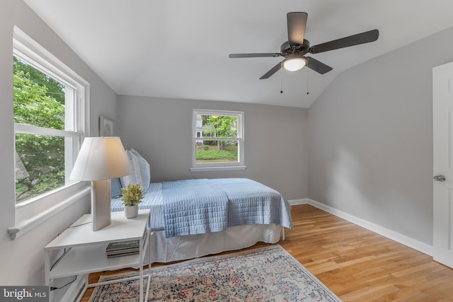 bedroom featuring vaulted ceiling, wood finished floors, baseboards, and ceiling fan