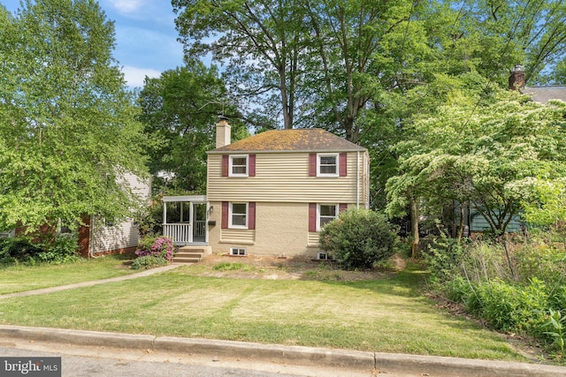 view of front facade featuring a front lawn and a chimney