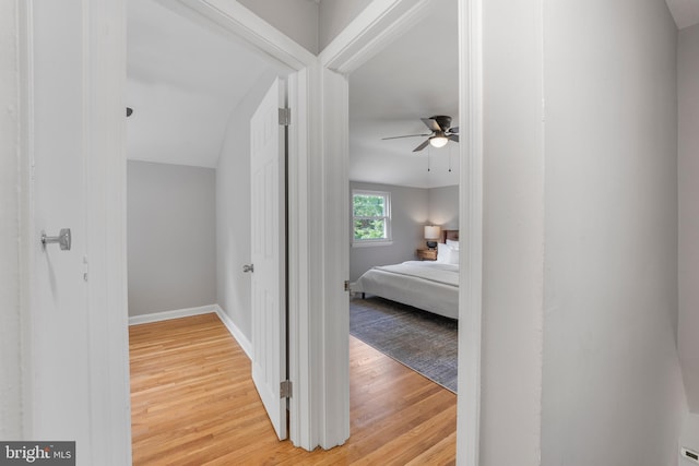 corridor with baseboards and light wood-type flooring