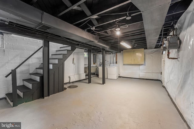 below grade area with electric panel, independent washer and dryer, and stairs