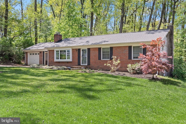 ranch-style home featuring a chimney, a front yard, brick siding, and an attached garage