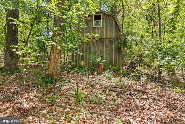 view of outbuilding featuring a forest view and an outbuilding