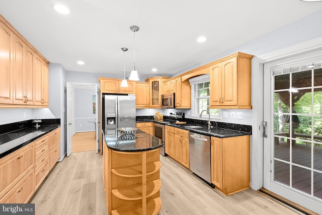 kitchen featuring stainless steel appliances, a sink, light wood-style flooring, glass insert cabinets, and recessed lighting