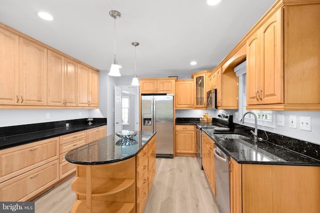 kitchen featuring stainless steel appliances, a sink, open shelves, light wood-style floors, and dark stone countertops