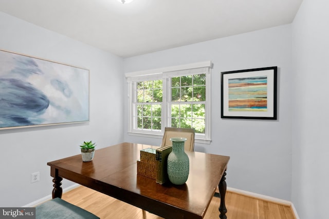 dining space with baseboards and wood finished floors