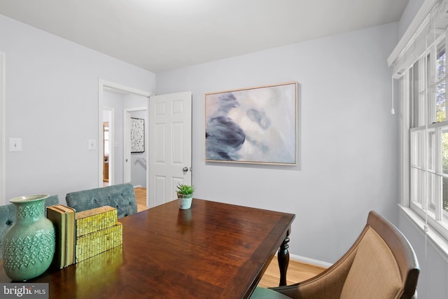 dining space featuring baseboards and light wood-style flooring