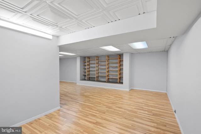 finished basement featuring wood finished floors and baseboards