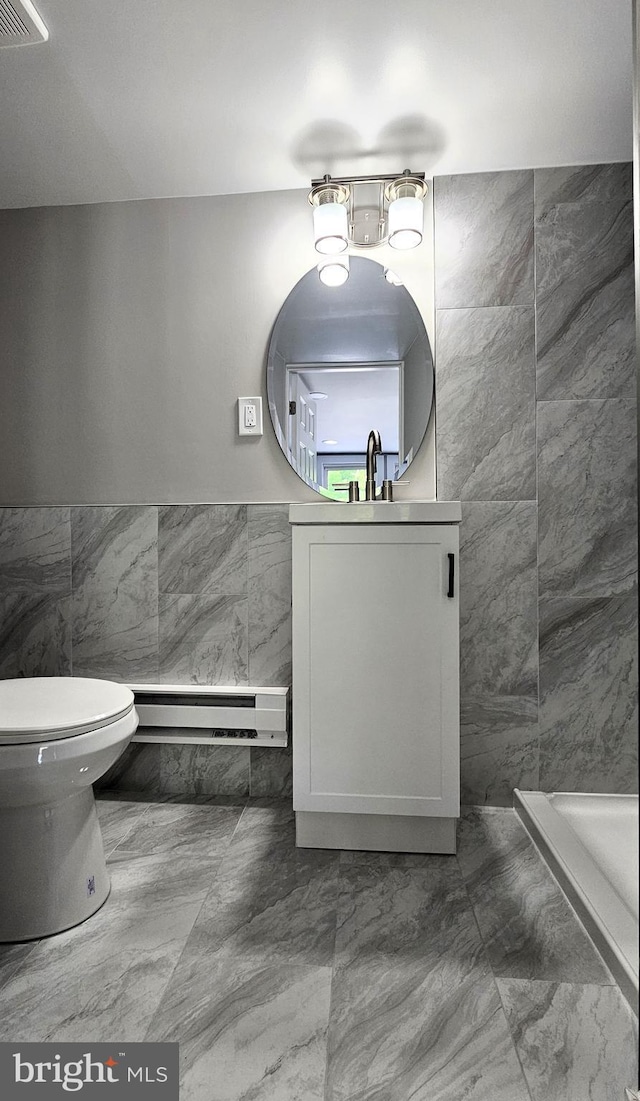 full bath featuring tile walls, visible vents, a shower stall, a baseboard heating unit, and vanity