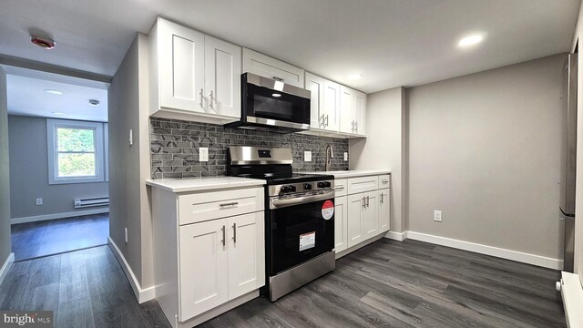 kitchen with dark wood-style flooring, baseboards, backsplash, light countertops, and appliances with stainless steel finishes