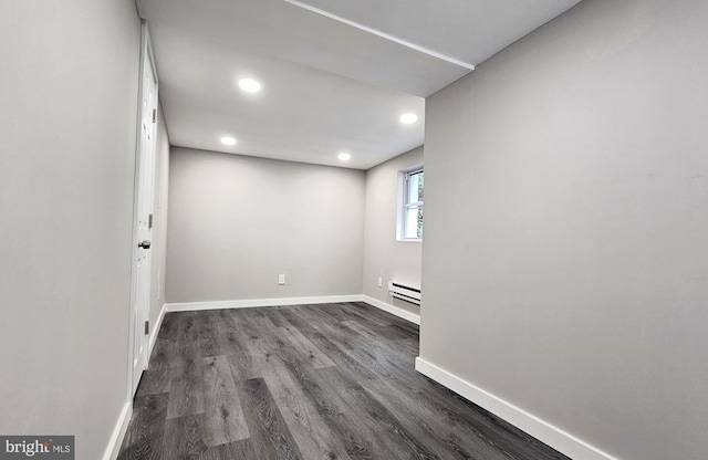 below grade area with a baseboard radiator, dark wood-style flooring, baseboards, and recessed lighting