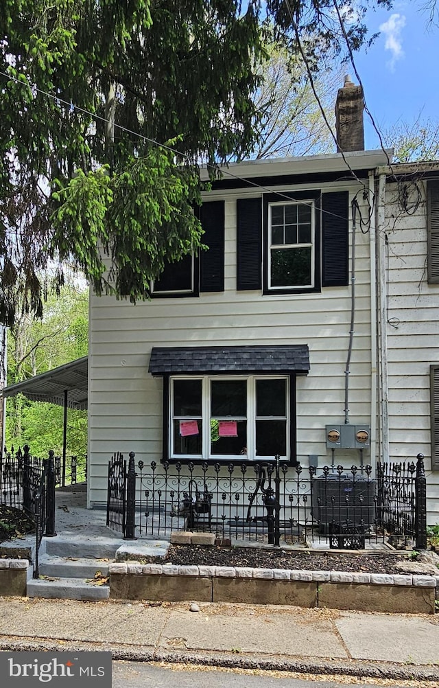 view of front of house with a chimney and fence private yard