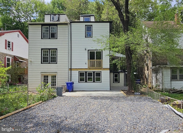 rear view of property with driveway and fence