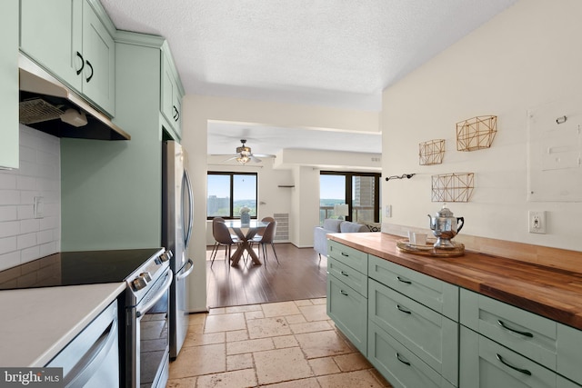 307 Yoakum Pkwy Unit 821, Alexandria, VA 22304 - kitchen with green cabinetry, butcher block counters, appliances with stainless steel finishes, a ceiling fan, and a textured ceiling