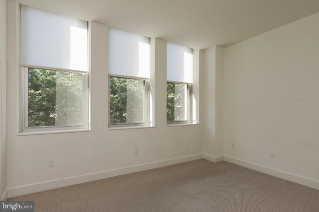 unfurnished room featuring carpet floors and baseboards